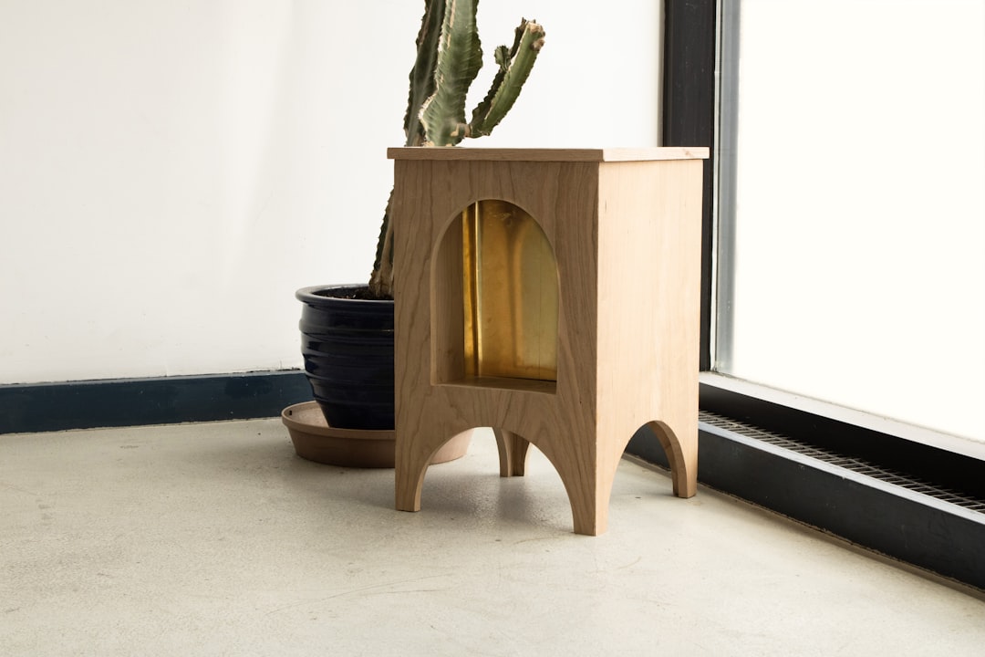 Wooden side table with arched cutout and plants